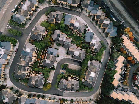 Aerial view of a modern neighborhood with roads and buildings in a lush urban setting.