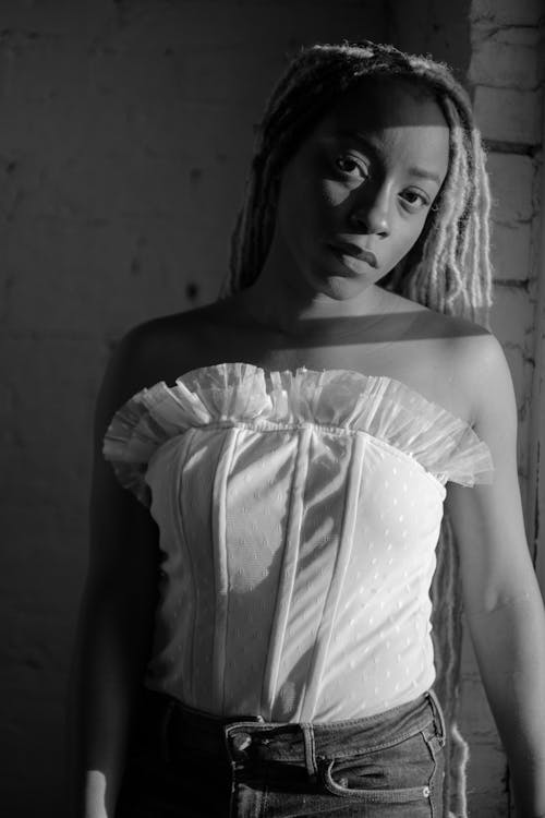 Woman in White Corset Standing Near Window