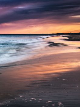 Captivating beach scene in Poland showcasing a vibrant sunset with reflections on the water.