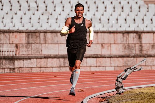 Free Focused male runner during a track race, showcasing determination and endurance. Stock Photo