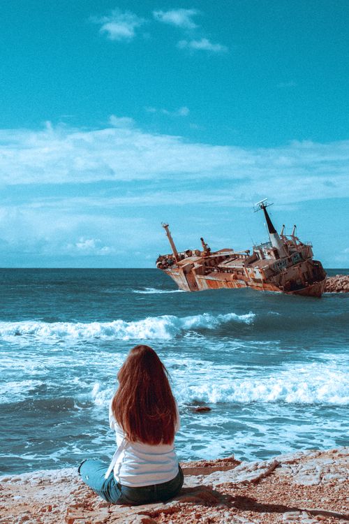 A Woman Sitting on a Seashore · Free Stock Photo