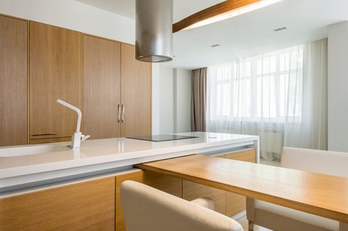 Free Interior of contemporary spacious kitchen with wooden table and chairs and comfortable chairs Stock Photo