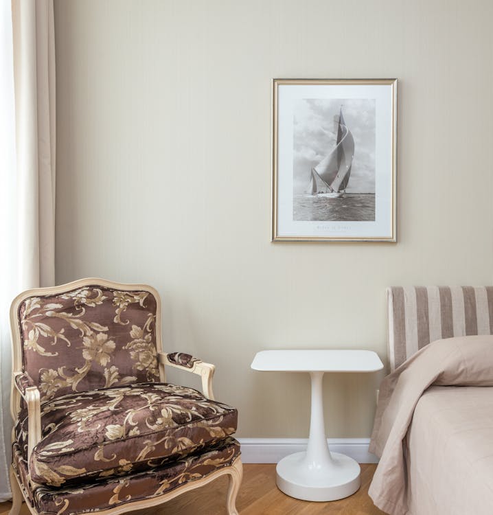 Free Comfortable armchair with classic design placed in corner of cozy bedroom near bed Stock Photo