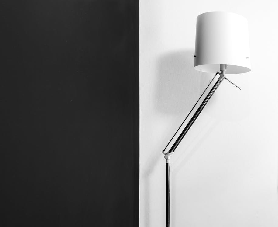 Modern lamp with stylish design near wall with contrast black and white colors in dwell room
