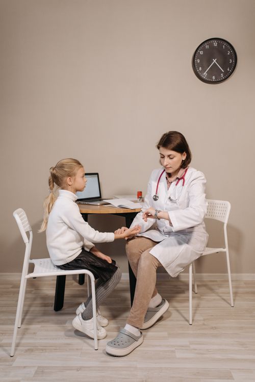 Free A pediatrician consults a young girl in a clinic setting, emphasizing healthcare and wellness. Stock Photo