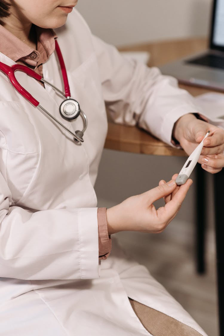 A Doctor Holding A Digital Thermometer 