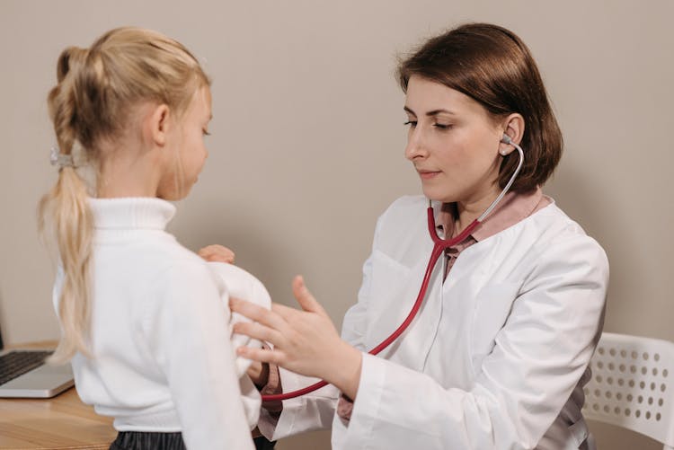 Doctor In White Lab Coat Examining Girl's Breath