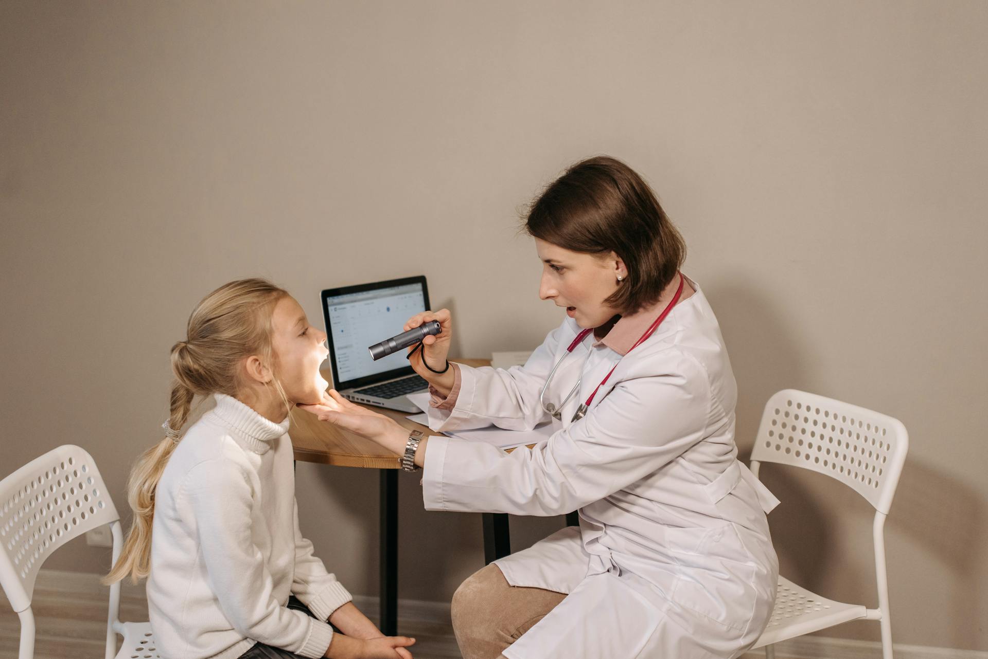 A female doctor examines a child in a clinic setting, ensuring proper medical care and attention.