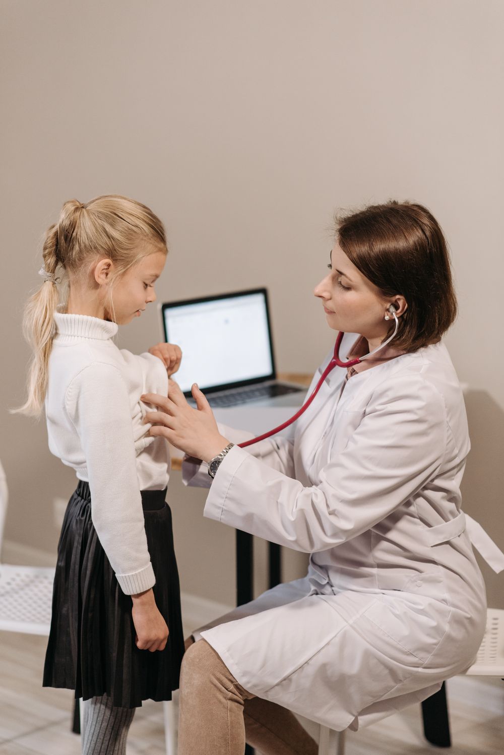 Female doctor examining a young girl with a stethoscope