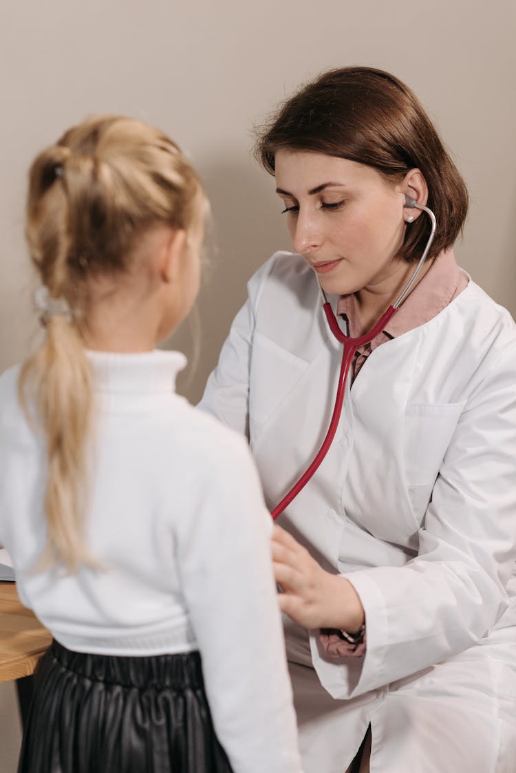 A Doctor Examining A Child Patient