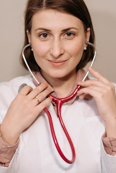 Portrait of a smiling female doctor holding a stethoscope indoors.