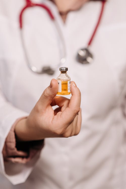 Close-Up Photo of a Person Holding a Vaccine in a Vial