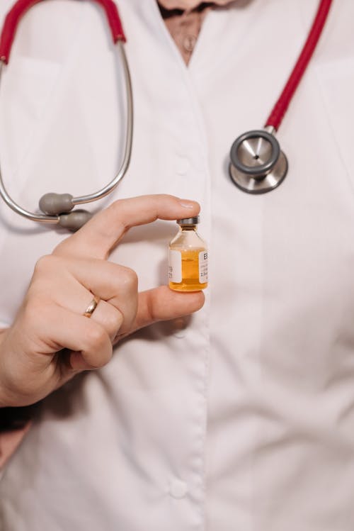 Free Close-Up Photo of a Person Holding a Vaccine in a Vial Stock Photo