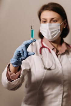 Medical professional with gloves holds a syringe, ready for vaccination.