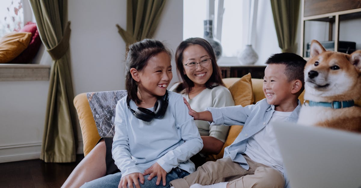 A Happy Family Sitting on the Couch while Playing with their Dog