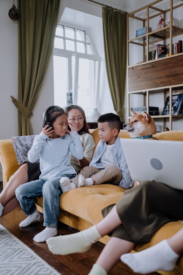 A Woman Sitting On The Couch With Her Kids