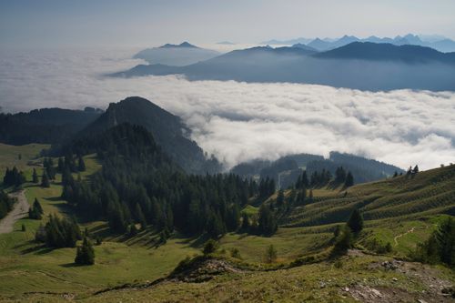 Free A breathtaking view of mountains covered in clouds with lush forest and scenic hills. Stock Photo