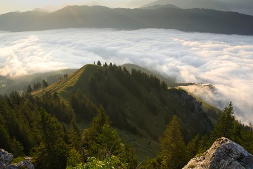 Free Breathtaking landscape of mountains covered in dense, rolling clouds and lush green forest. Stock Photo