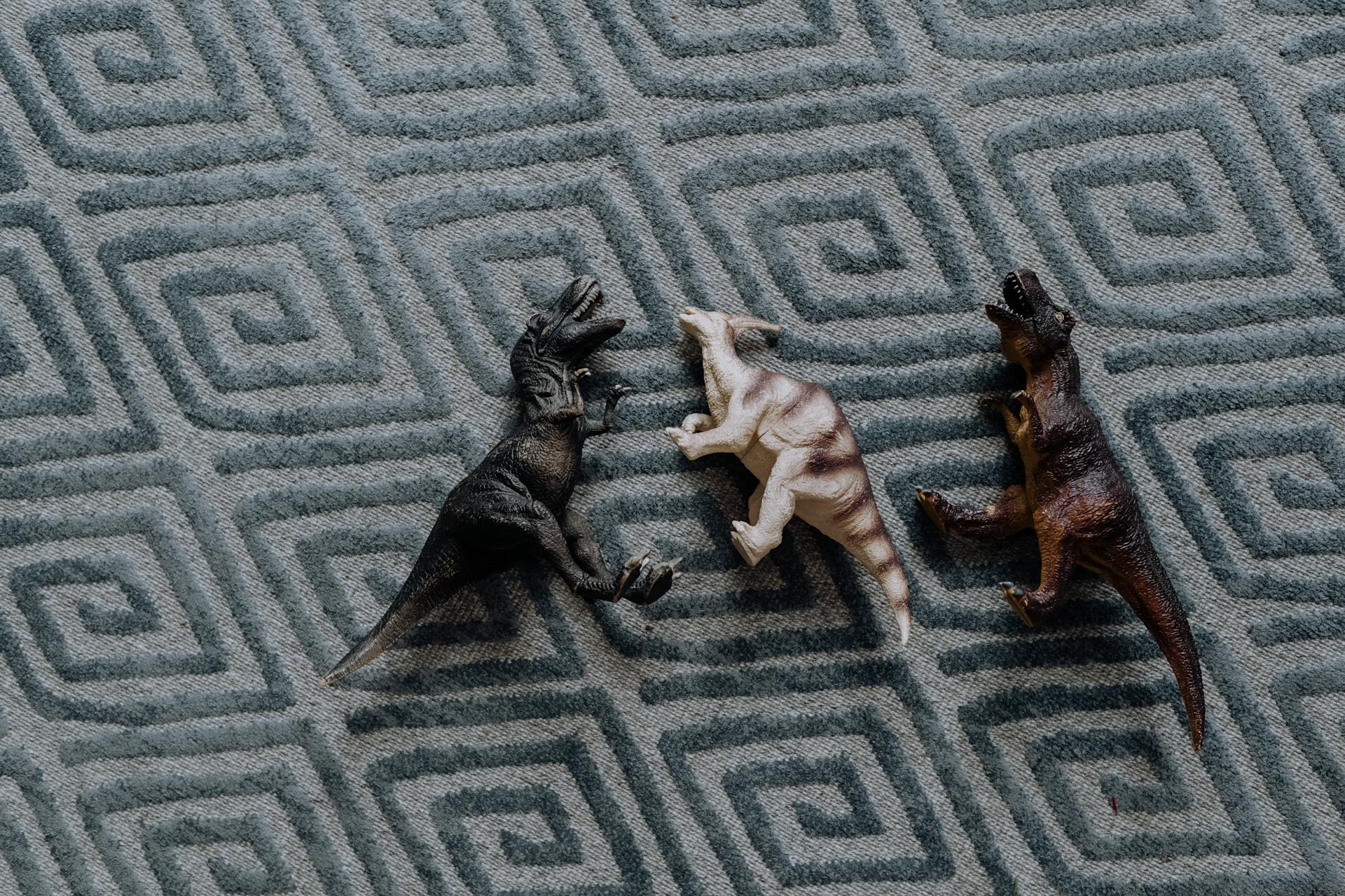 A Dinosaur Toys Lying on the Carpet