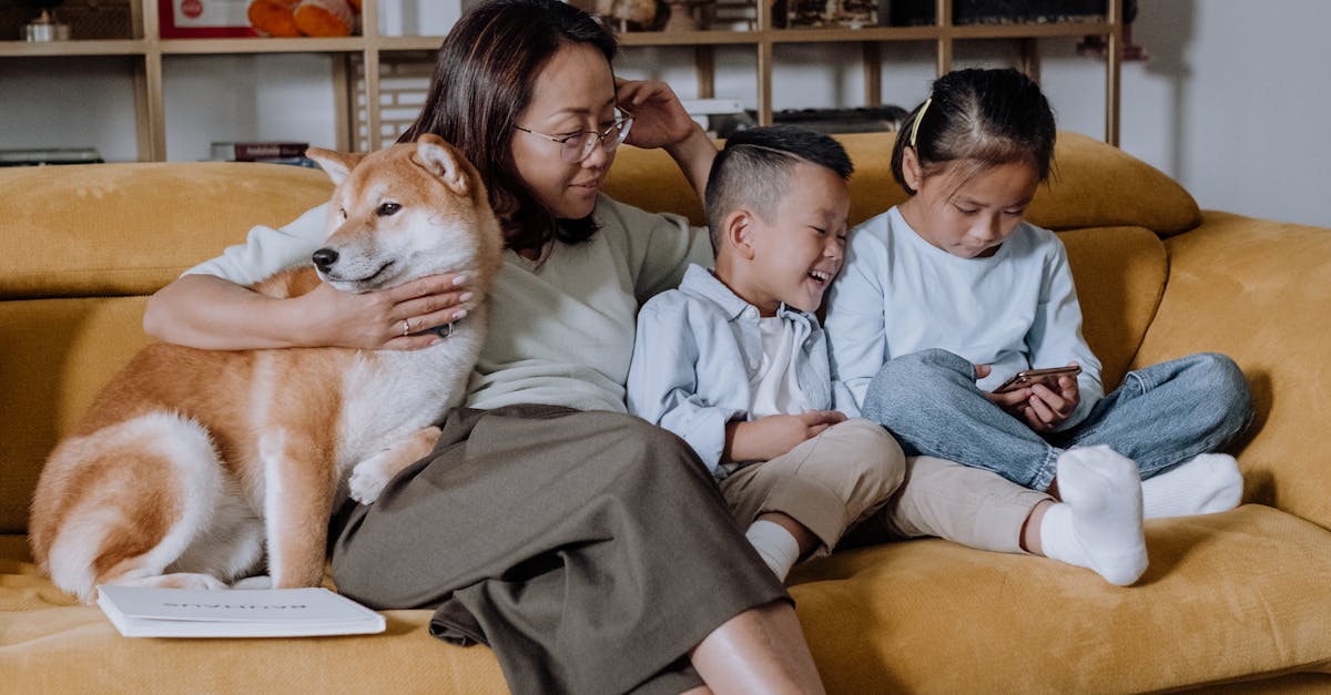 A Mother Sitting on the Couch with Her Kids and Their Dog