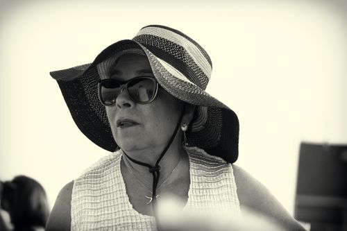 Free A fashionable woman wearing a large sun hat and sunglasses, captured in black and white. Stock Photo