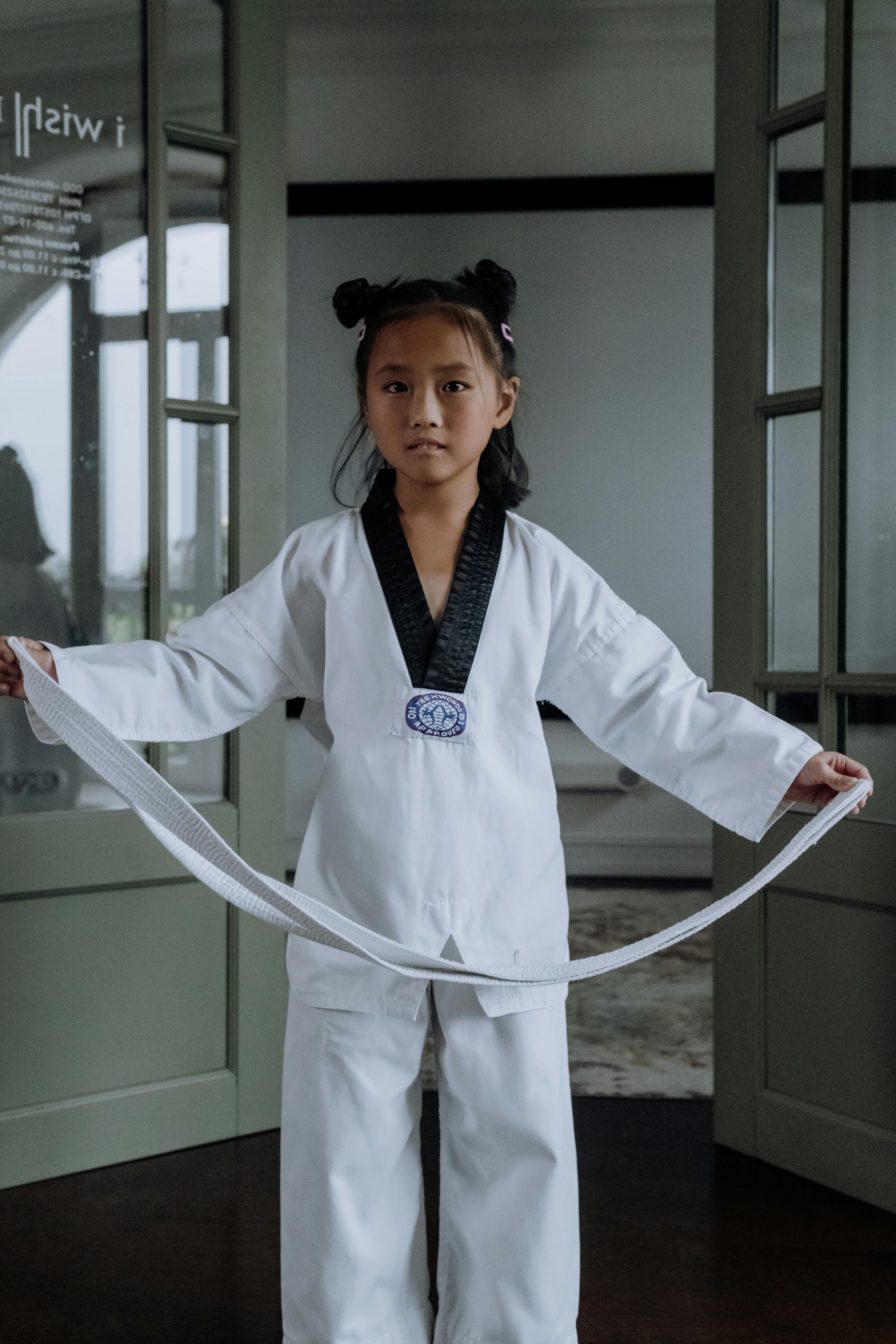 girl in karategi holding a white belt