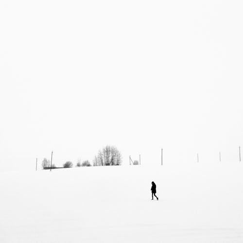 Person Walking on Snow Covered Field