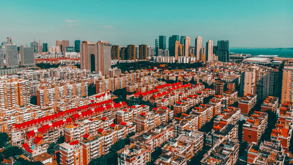 Unbeatable All-Inclusive Mutianyu Great Wall Hiking and Helicopter Overlook Tour Review 2026 - Aerial view of Xiamen's urban skyline featuring vibrant red-topped buildings under a clear sky.