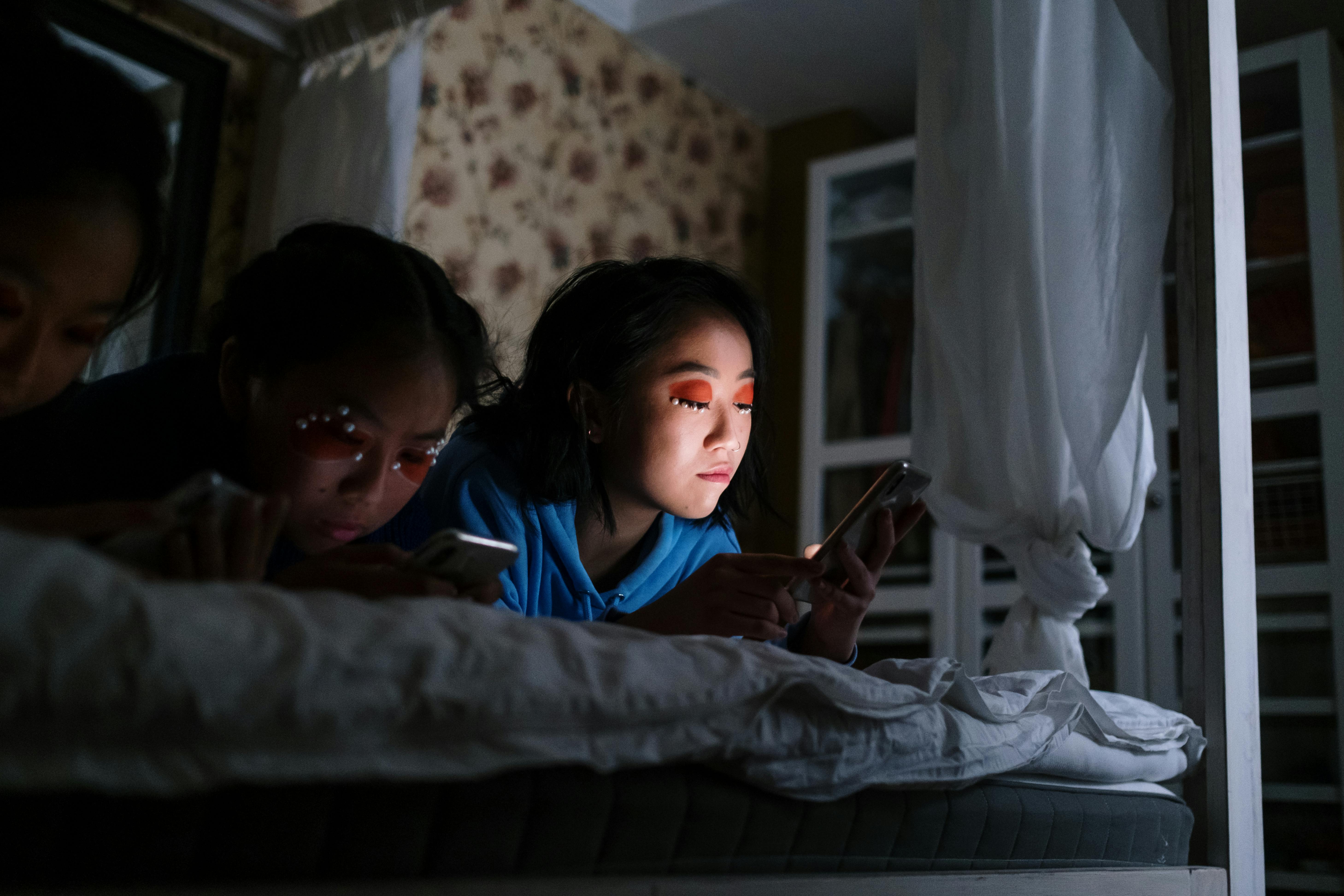 boy in blue shirt lying on bed beside girl in blue shirt