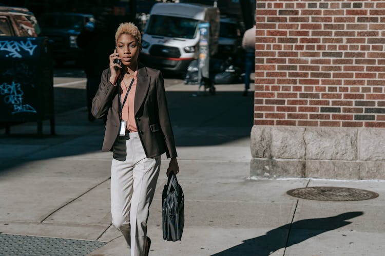 Stylish Young Black Businesswoman Crossing Road And Having Phone Call