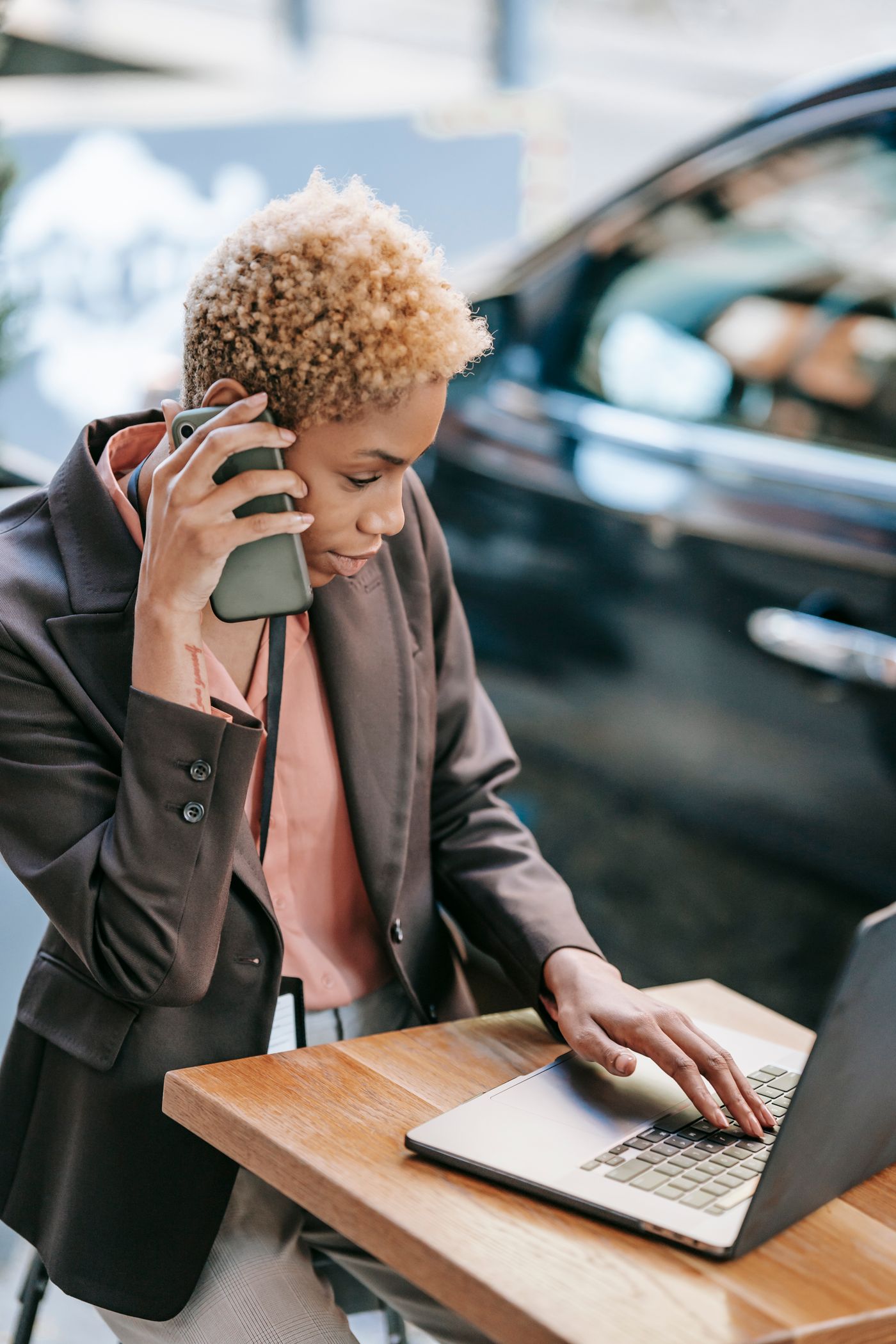 Black businesswoman using a laptop and phone while working