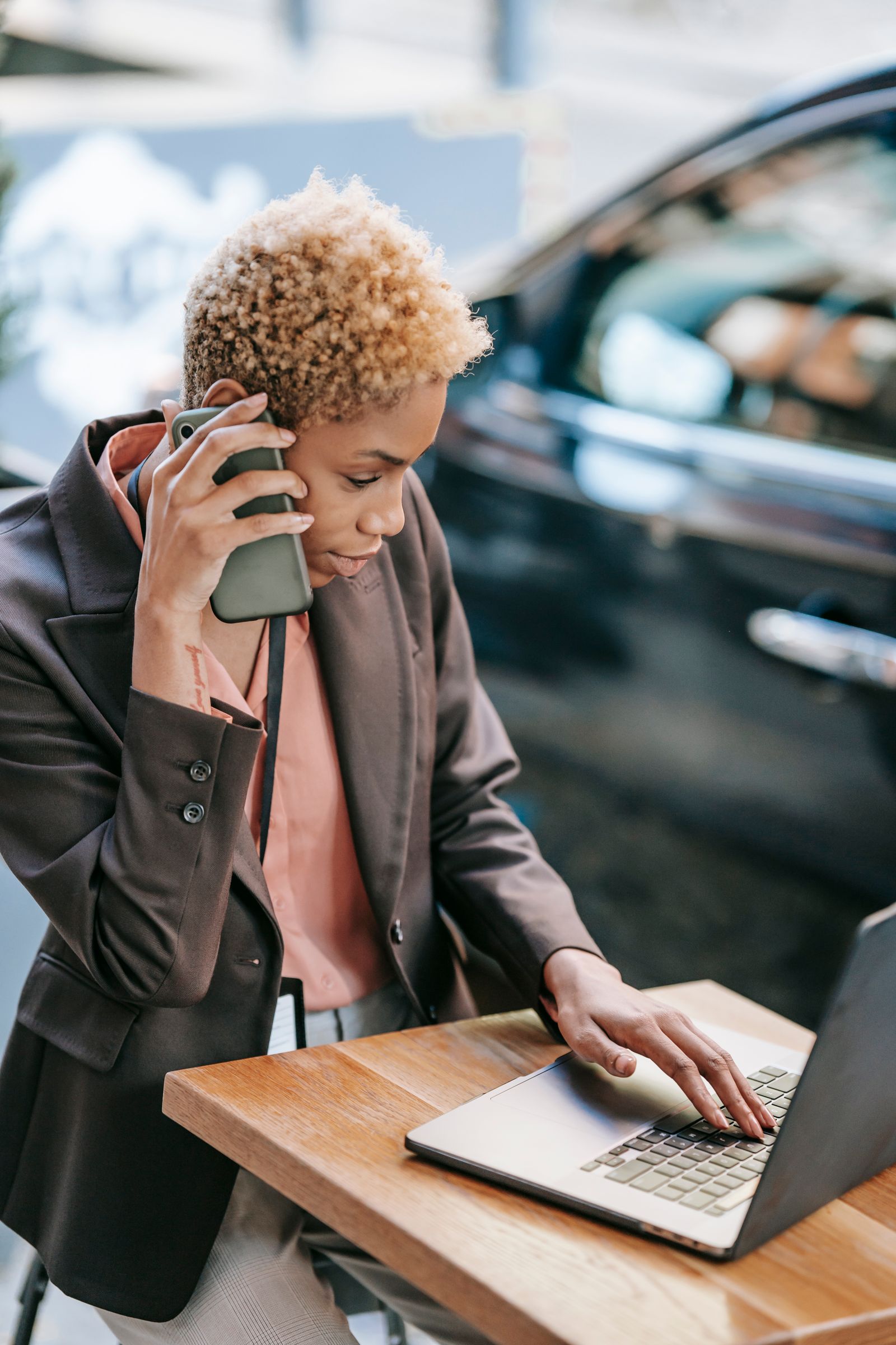African business professional using a smartphone and laptop while managing a digital customer journey