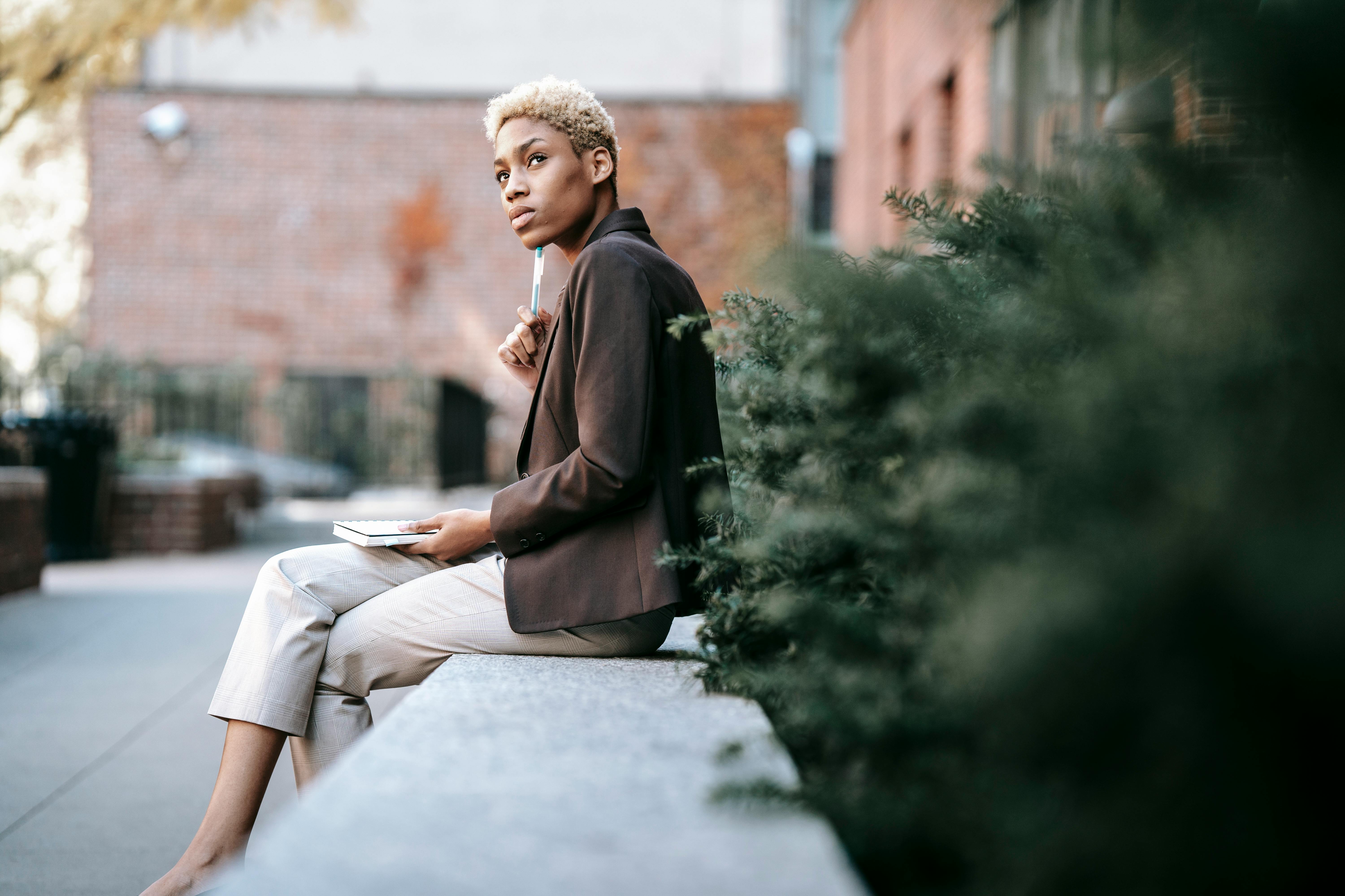 pensive black female entrepreneur taking notes in notepad