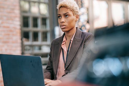 Thoughtful black woman using laptop for business project