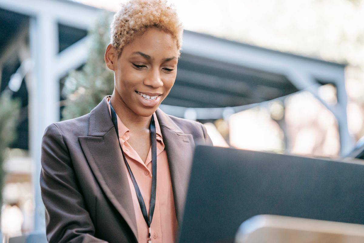 Nigerian fintech professional working at a laptop
