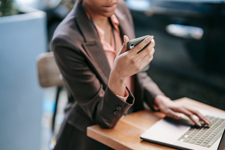 Black Woman Surfing Laptop And Using Smartphone