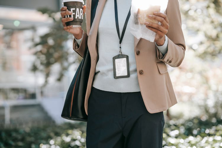 Ethnic Businesswoman With Coffee And Sandwich Walking To Work