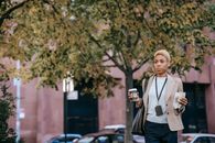 Serious black woman with coffee and sandwich