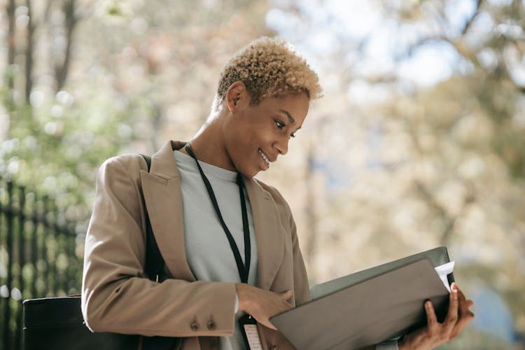 Cheerful Businesswoman Reading Documents In Folder