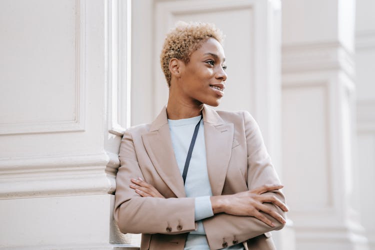 Smiling Black Entrepreneur With Folded Arms In Town