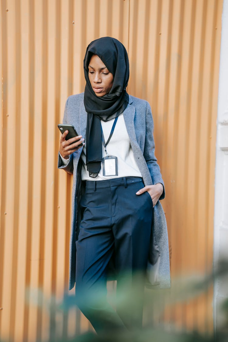 Confident Young African American Businesswoman Reading Message On Smartphone On Street