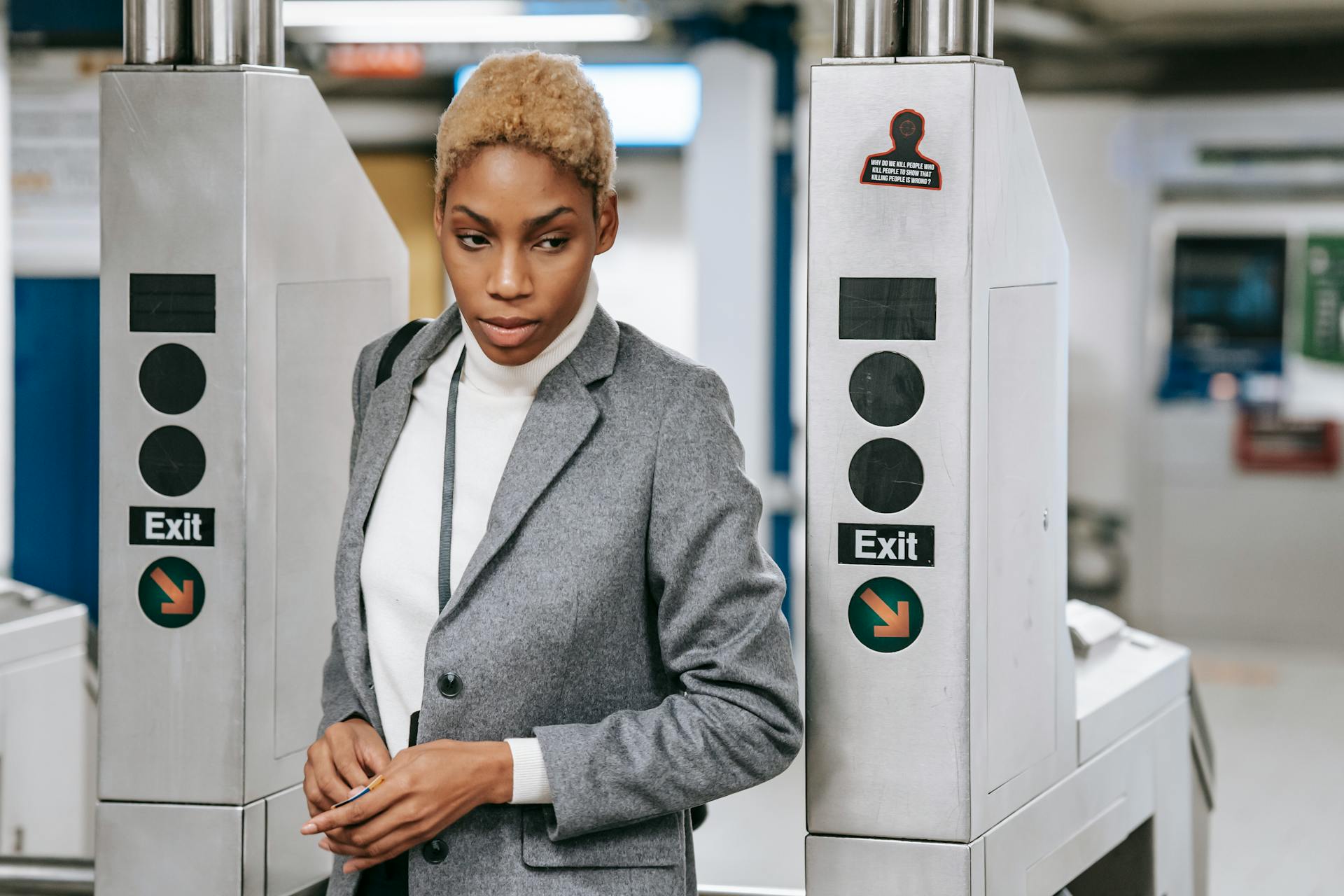 Elegant woman in stylish business attire exiting a modern subway station.