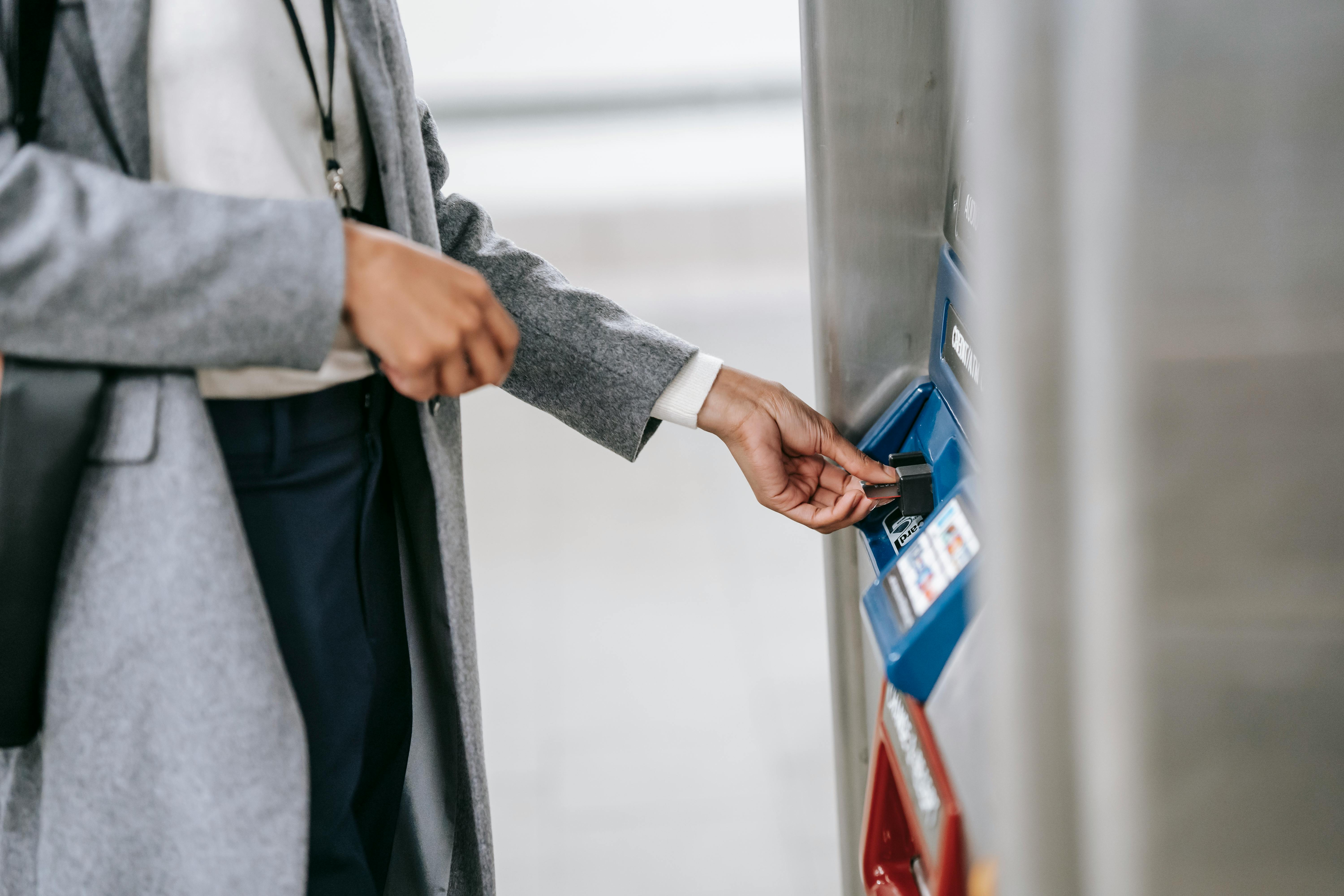 faceless woman buying metro ticket via electronic machine