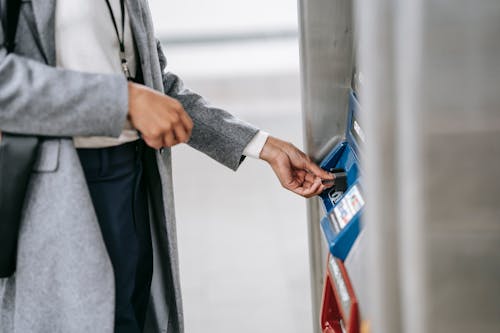 Faceless woman buying metro ticket via electronic machine