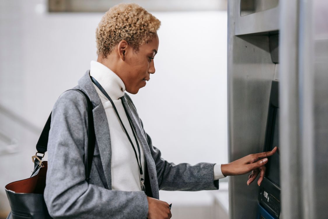 Young African American woman touching screen of ticket machine in metro ...