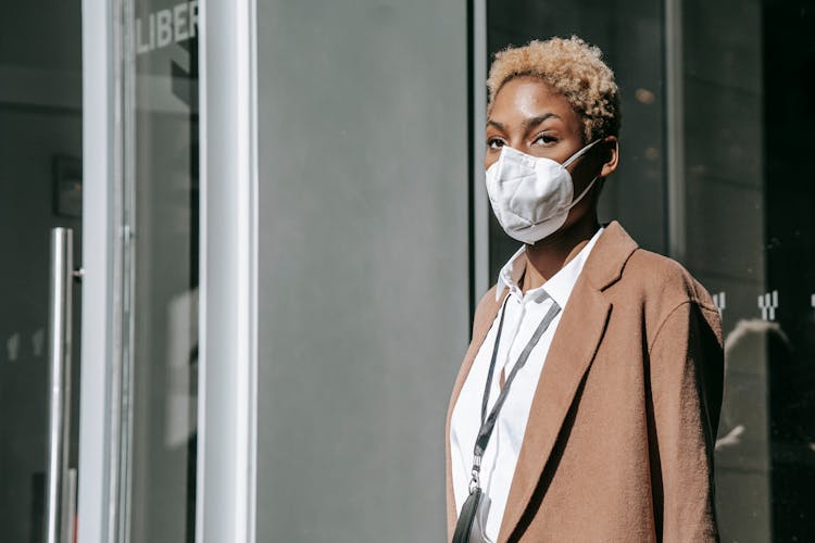 Pensive Young Black Businesswoman In Mask Standing On Street During Pandemic