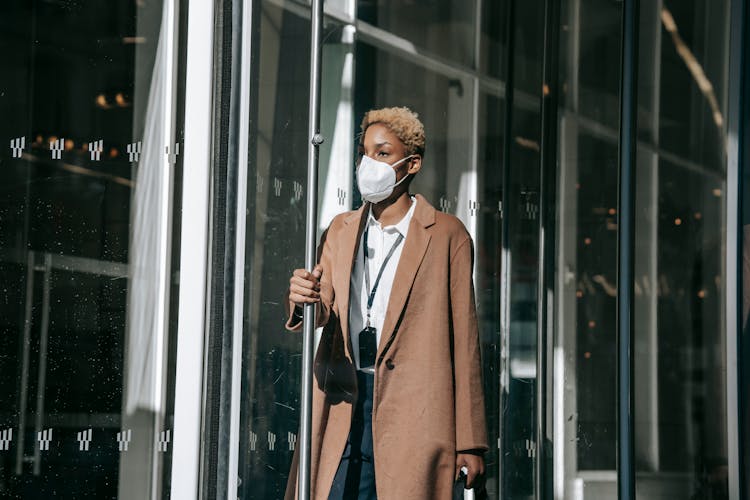 Serious Young Black Lady In Mask Opening Modern Building Door After Workday