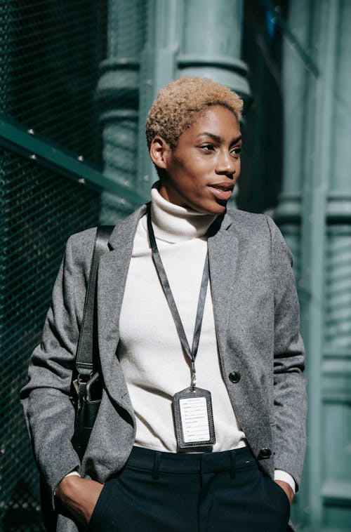 Free Self assured young black businesswoman standing on street with hands in pockets Stock Photo