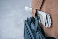 Unrecognizable businesswoman with bag and newspaper