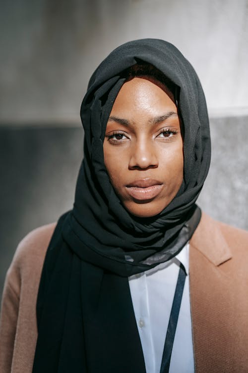 Mujer En Hijab Negro Y Chaqueta Marrón